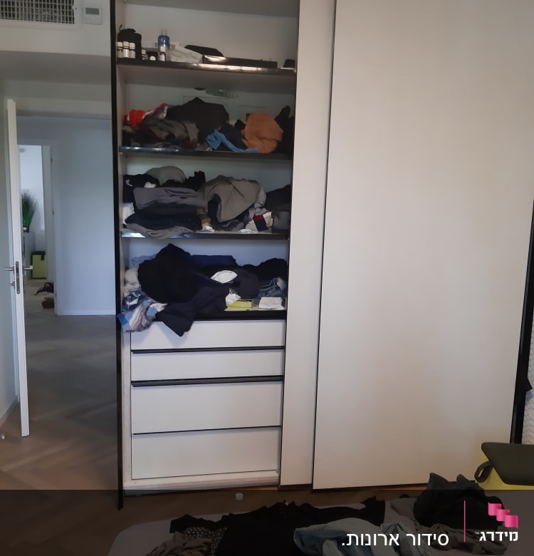 ארון בגדים פתוח עם בגדים מקופלים ומבולגנים